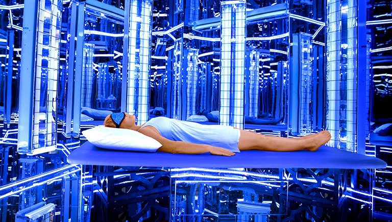 A woman laying on the ground in front of some blue lights